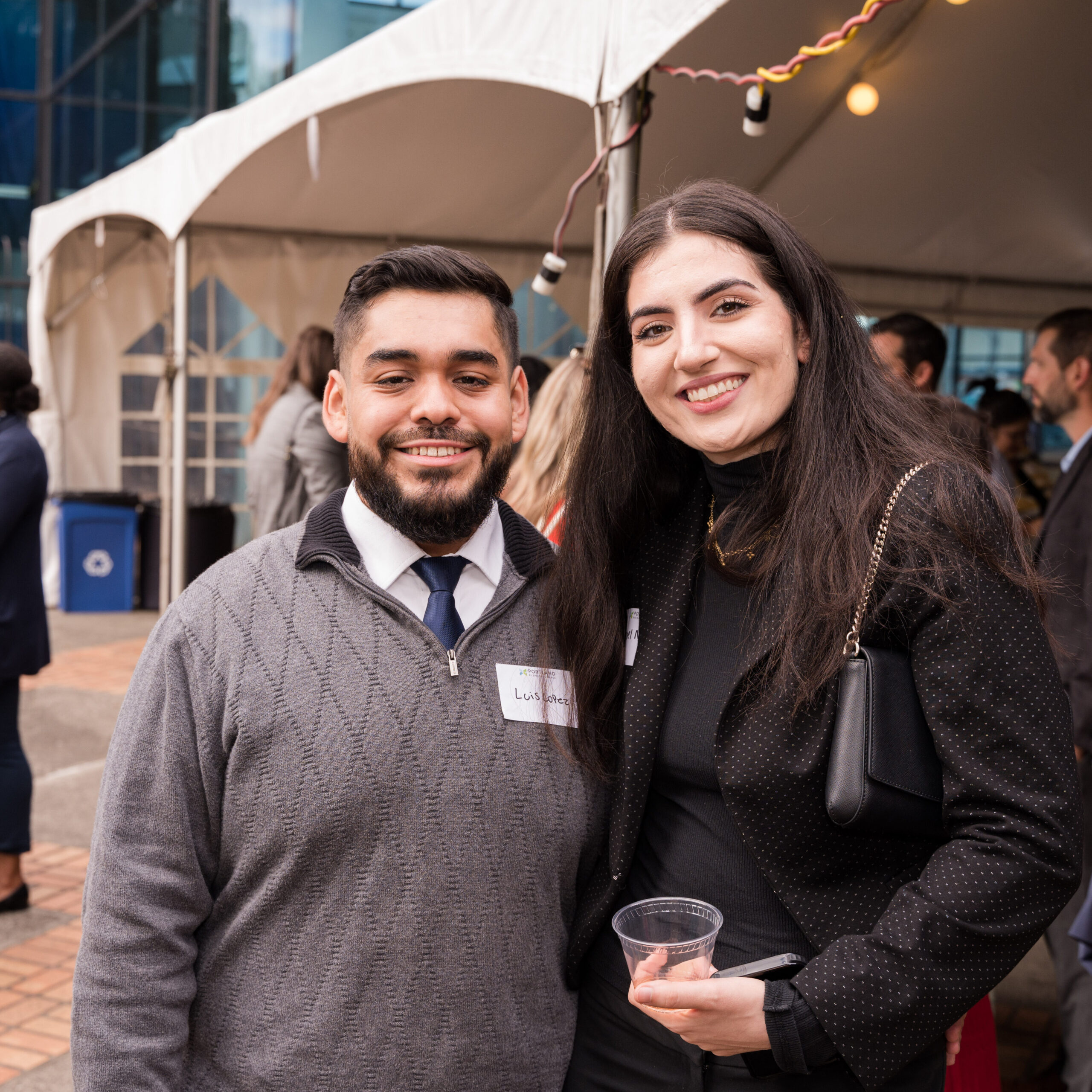 Two friends pose for a picture together smiling at a Chamber event