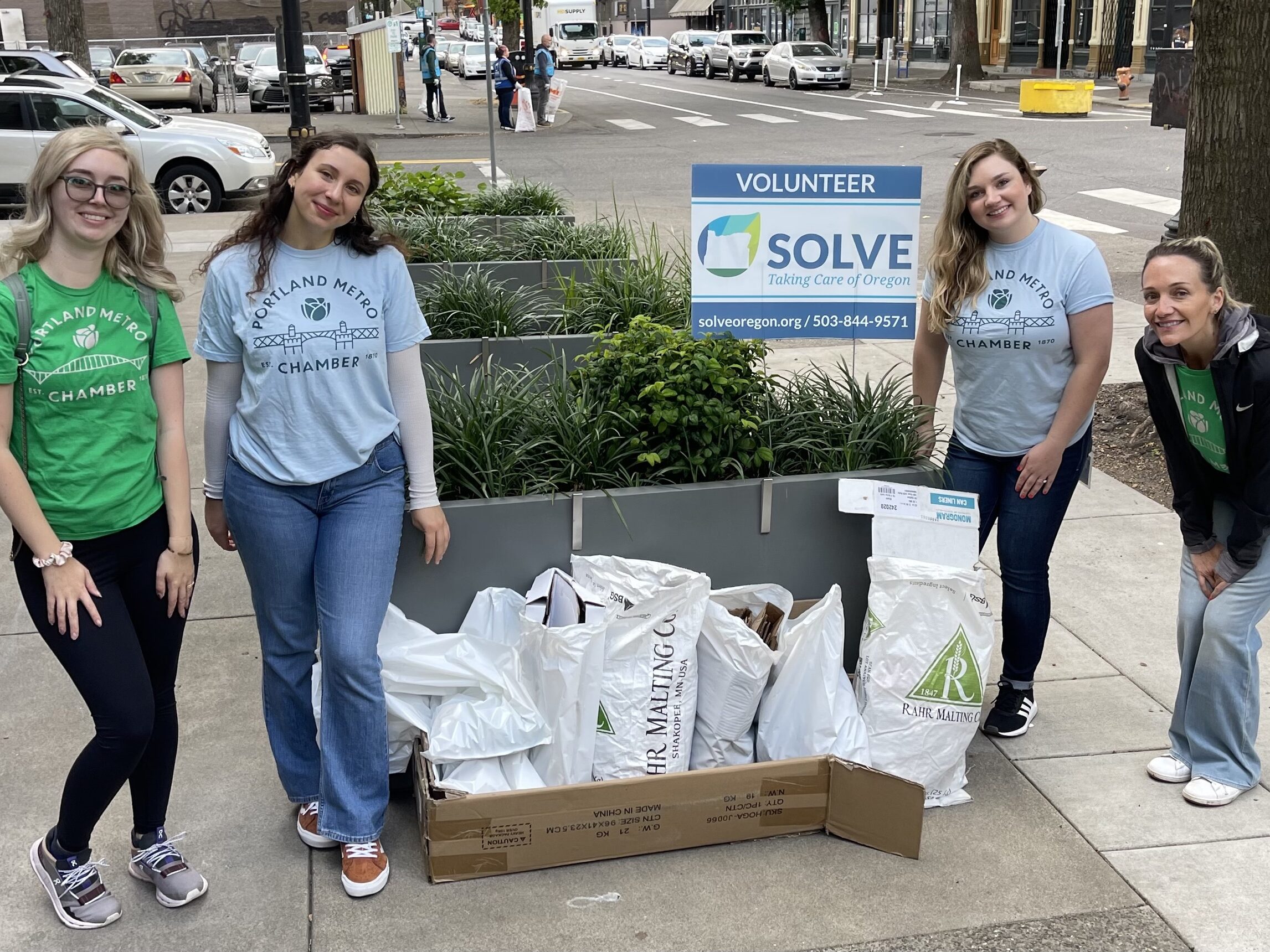 Four members of the Equity Council standing next to bagged trash at a SOLVE clean-up event.
